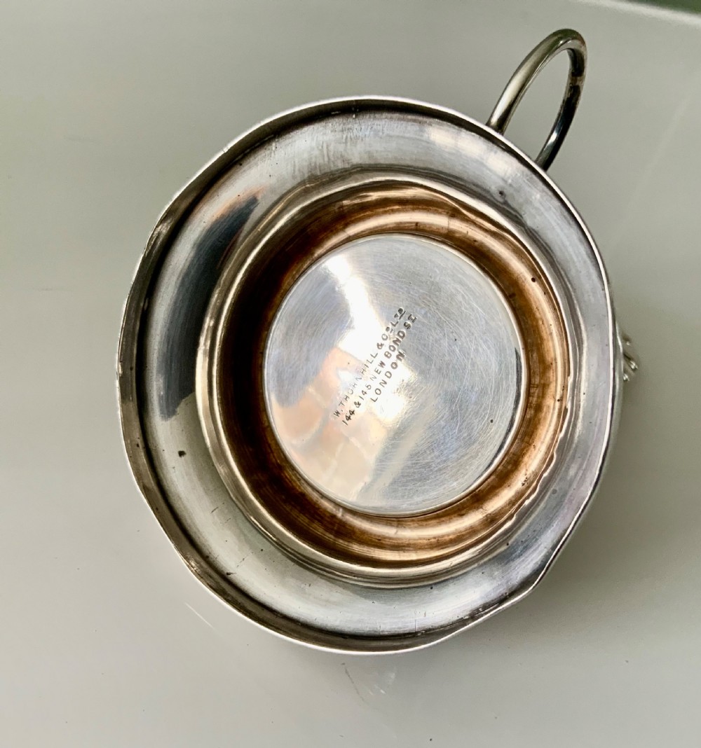 A Victorian silver night light holder featuring a rounded base holding a small wax candle beneath a scalloped shell-shaped reflector shade. View VII