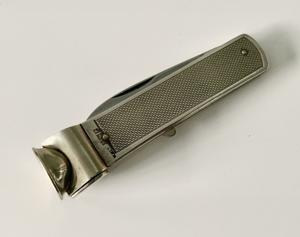 A hallmarked sterling silver pocket knife featuring an engine-turned textured body, a single steel blade, and an integrated cigar cutter at the end. View III