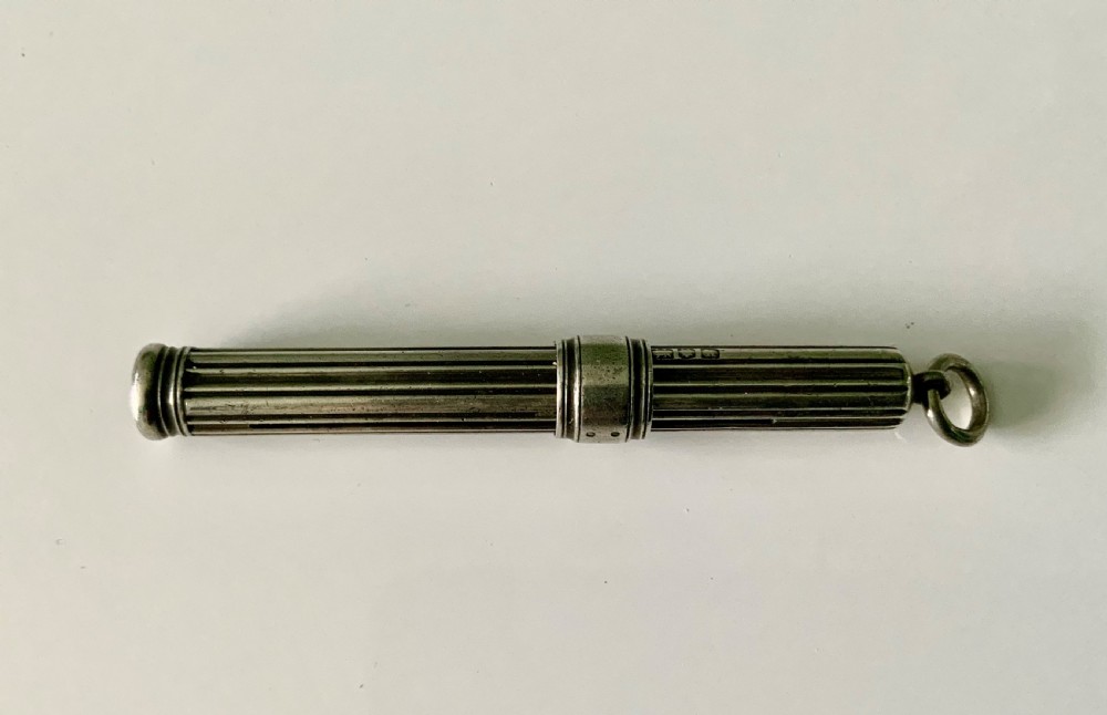 A Victorian fluted sterling silver sliding pencil featuring hallmark stamps and a top suspension ring. View IV