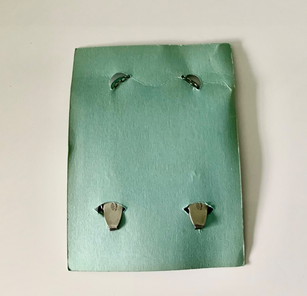 An Art Deco sterling silver bib holder featuring two engraved rabbit-shaped clips connected by a fine silver chain. View II