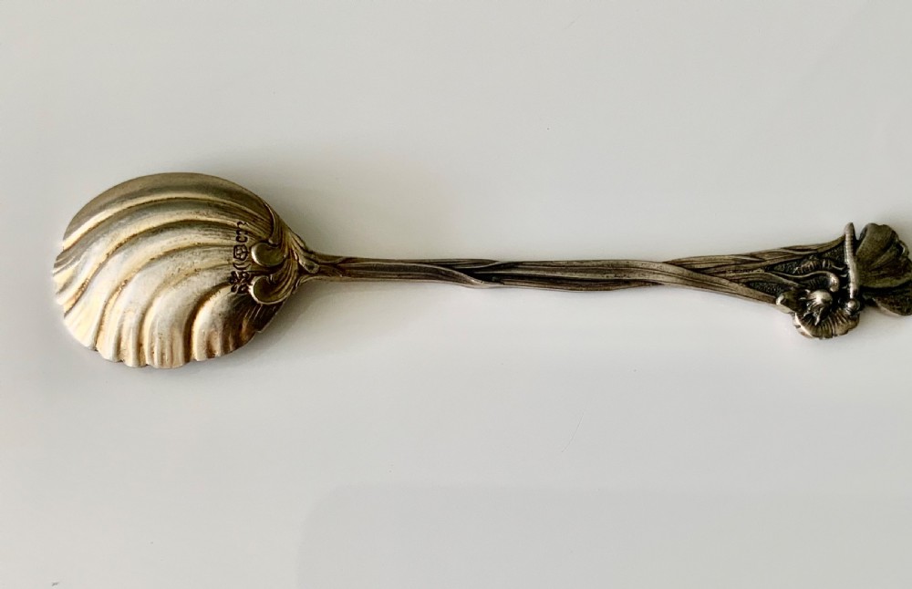 A set of six Art Nouveau silver teaspoons with shell bowls and floral stems, displayed inside an open fitted cloth-lined presentation box. View IV