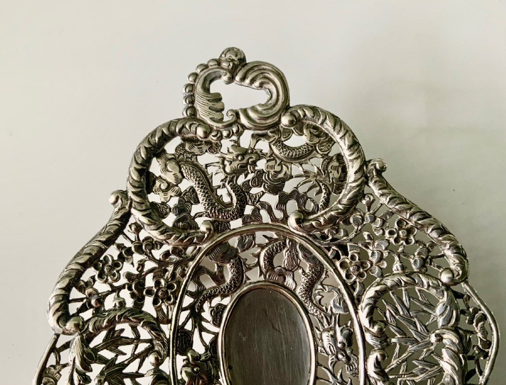 An oval Chinese export silver dish featuring pierced openwork decorated with chased dragons, bamboo foliage, and integrated side handles. View II