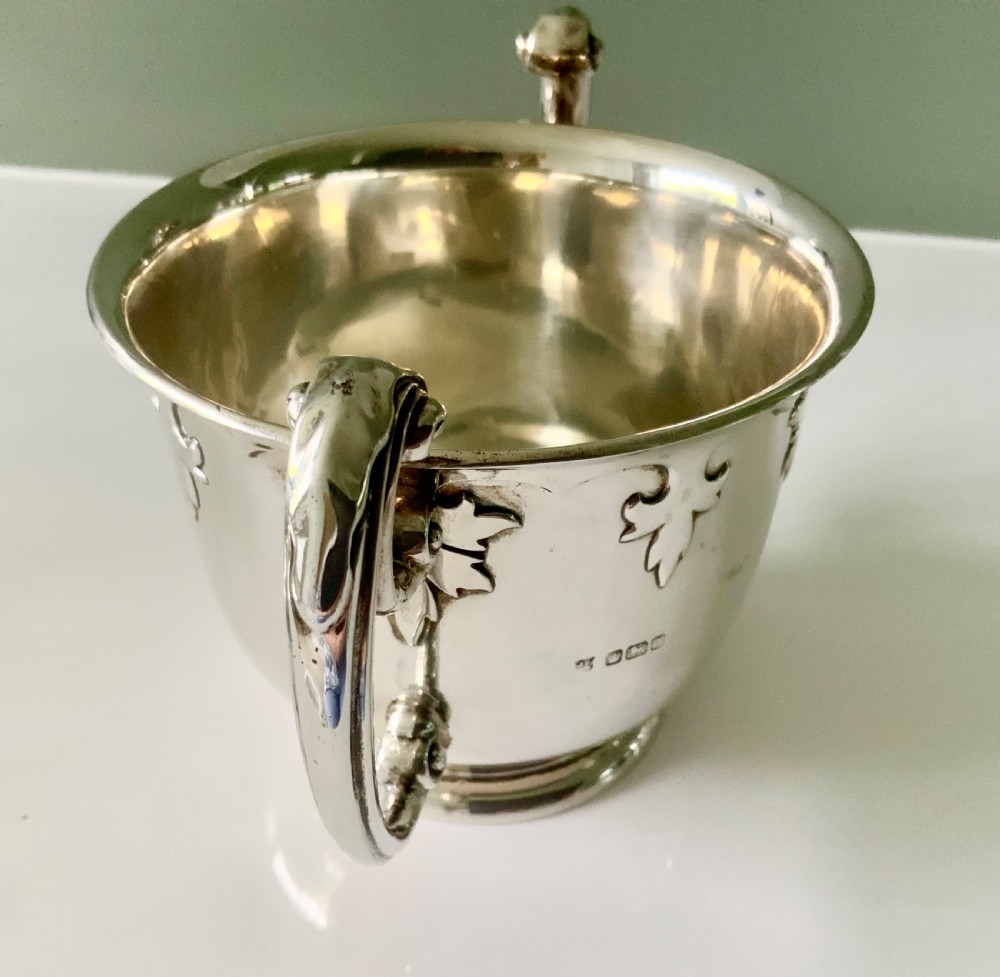 A polished silver loving cup featuring two prominent scroll handles and embossed leaf detailing around the body. View III
