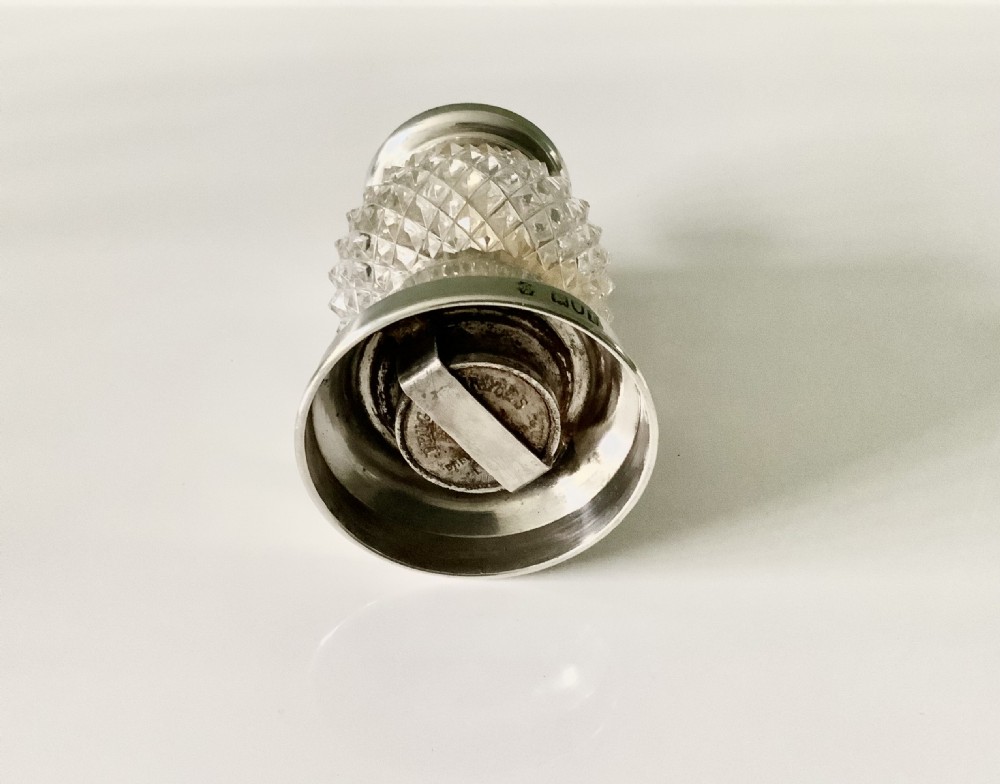 An Edwardian sterling silver and cut glass pepper grinder featuring diamond-patterned glass and hallmarked silver mounts. View III