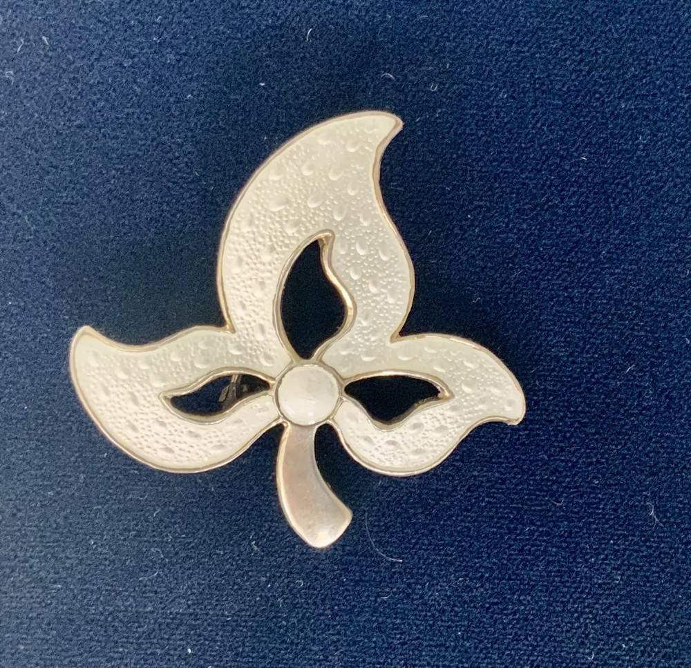An off-white leaf-shaped Scandinavian silver-gilt enamel brooch featuring textured raindrop patterns.
