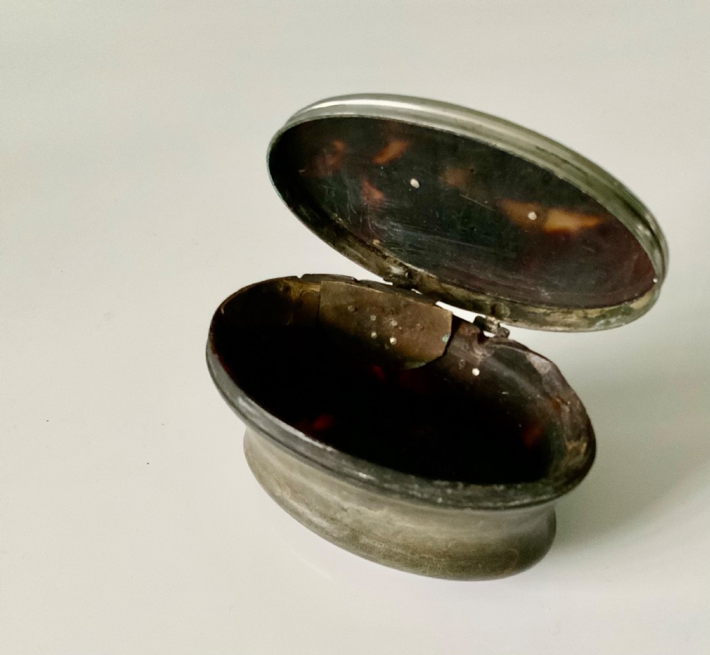 An oval antique Scottish snuff mull with a dark horn body and a fitted silver-mounted lid featuring an inset blank shield. View V