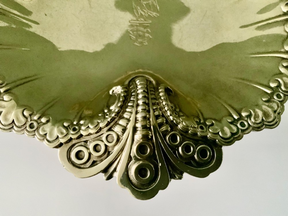 A Victorian shell-shaped silver-gilt dish with lobed fluting, a scalloped scroll rim, and an engraved crest at the centre. View III