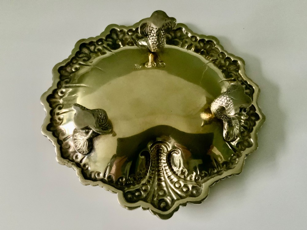A Victorian shell-shaped silver-gilt dish with lobed fluting, a scalloped scroll rim, and an engraved crest at the centre. View IV