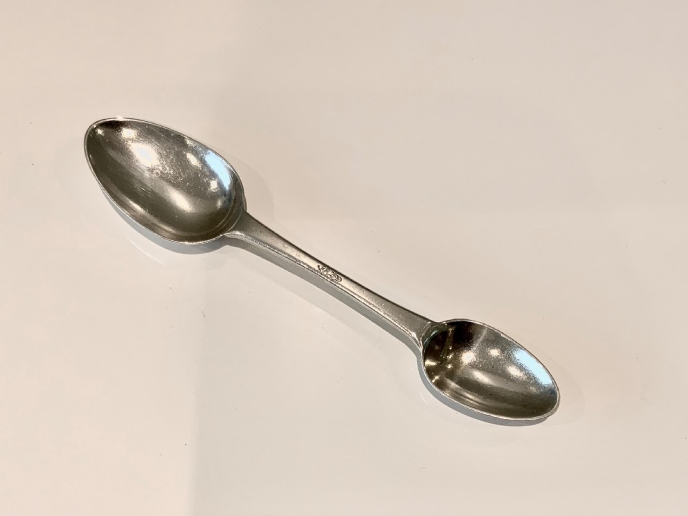 An antique Victorian double-ended silver medicine spoon featuring a small oval bowl at one end and a larger bowl at the opposite end.