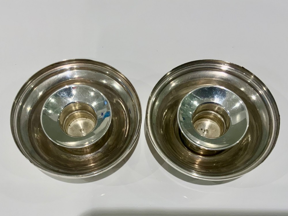 A pair of circular silver travelling candlesticks with flared nozzles and decorative beaded and teardrop filigree motifs along the conical bases. View III