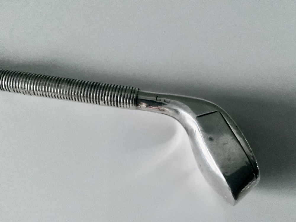 A sterling silver button hook featuring a handle shaped like a golf club head with a textured grip. View III