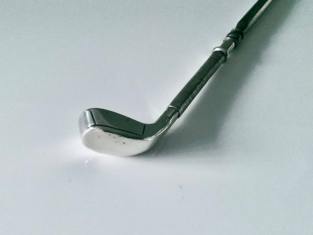 A sterling silver button hook featuring a handle shaped like a golf club head with a textured grip. View IV