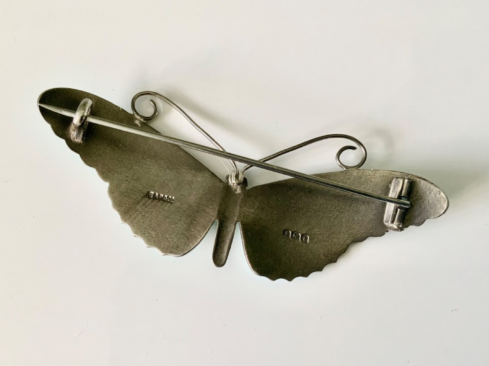A silver butterfly brooch with turquoise guilloche enamel wings, dark purple central body, and wire antennae. View II