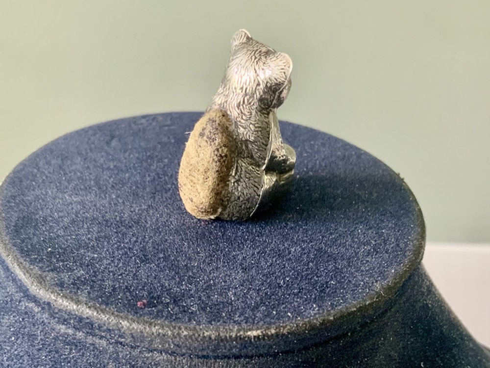 A miniature antique sterling silver pin cushion crafted in the form of a seated teddy bear with textured fur detail. View II