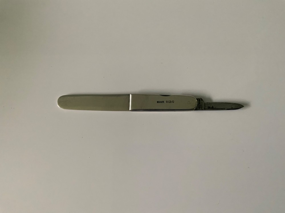 A sterling silver folding letter opener knife combination displaying hallmarked stamps along its casing. View II