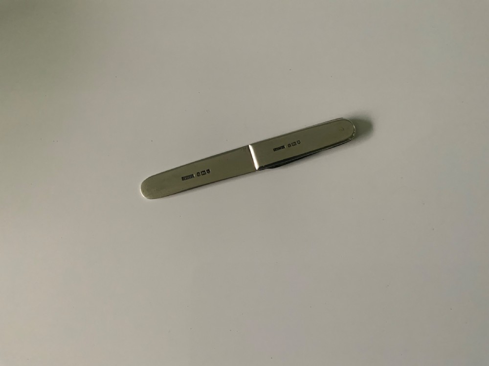 A sterling silver folding letter opener knife combination displaying hallmarked stamps along its casing. View III