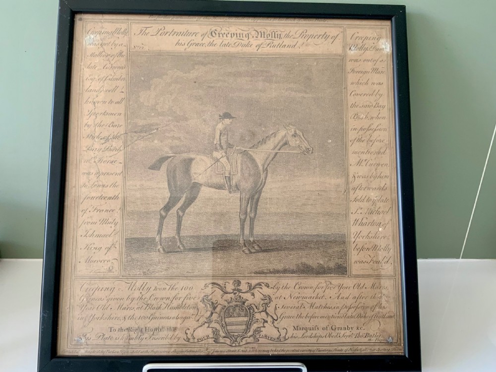 A framed 18th-century copperplate engraving depicting the racehorse Creeping Molly alongside jockey, detailed text panels, and a heraldic coat of arms.