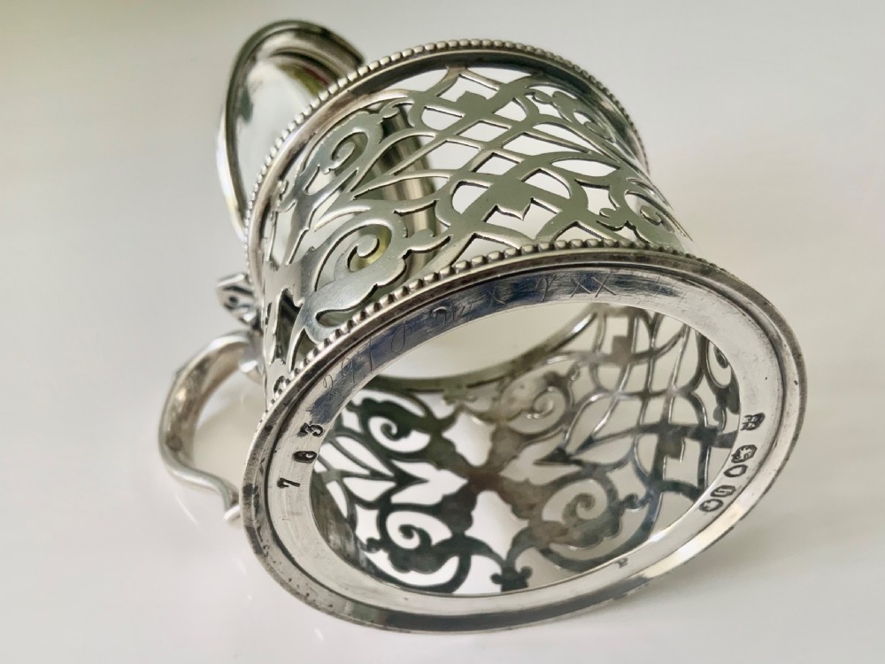 A pierced silver mustard pot with an engraved hinged lid, beaded rims, and a visible ruby red glass liner. View VII
