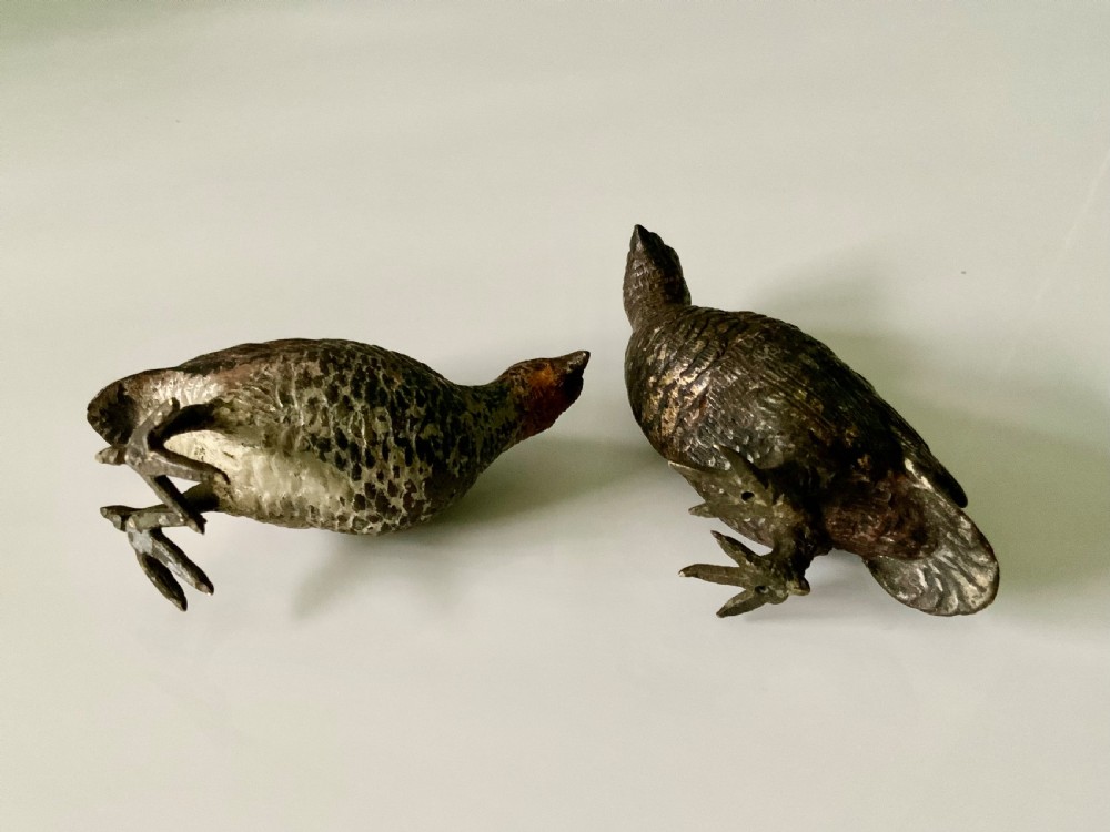 A pair of small, detailed cold-painted bronze figures depicting standing grouse birds with textured feathering. View IV