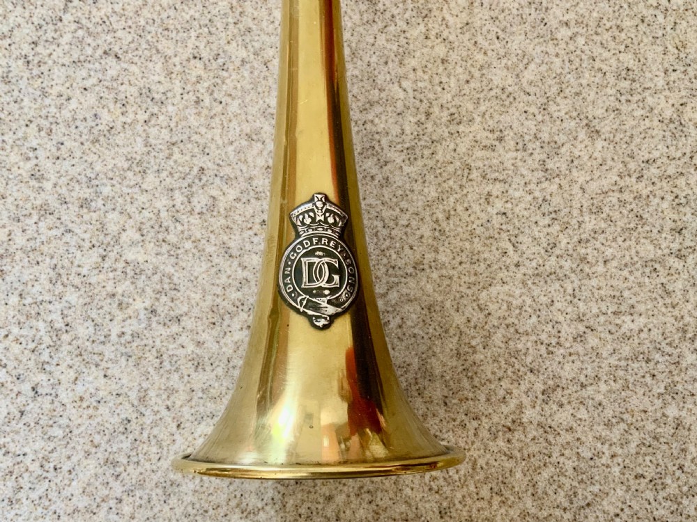 A long, straight late 19th-century brass coaching horn featuring a slender cylindrical body and a flared circular bell. View II