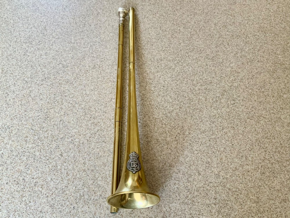 A long, straight late 19th-century brass coaching horn featuring a slender cylindrical body and a flared circular bell. View IV