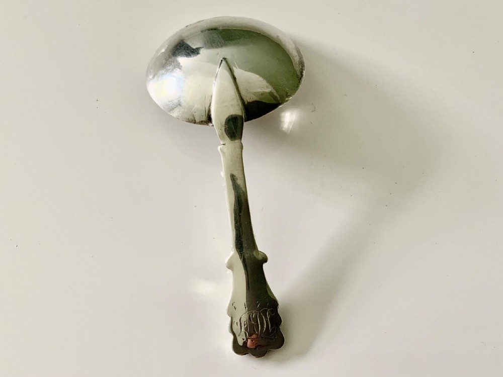 A Victorian sterling silver caddy spoon with a round engraved bowl and a fluted handle. View II