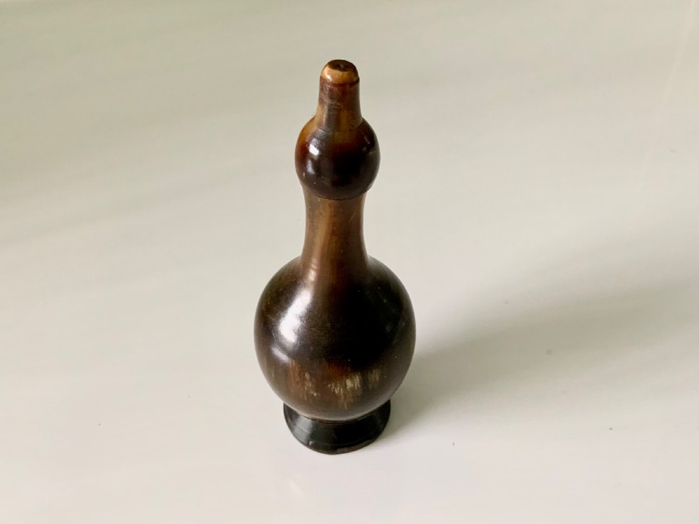 A 19th-century turned horn glove powderer featuring a rounded bulbous base, a narrow neck, and a polished dark brown finish. View IV
