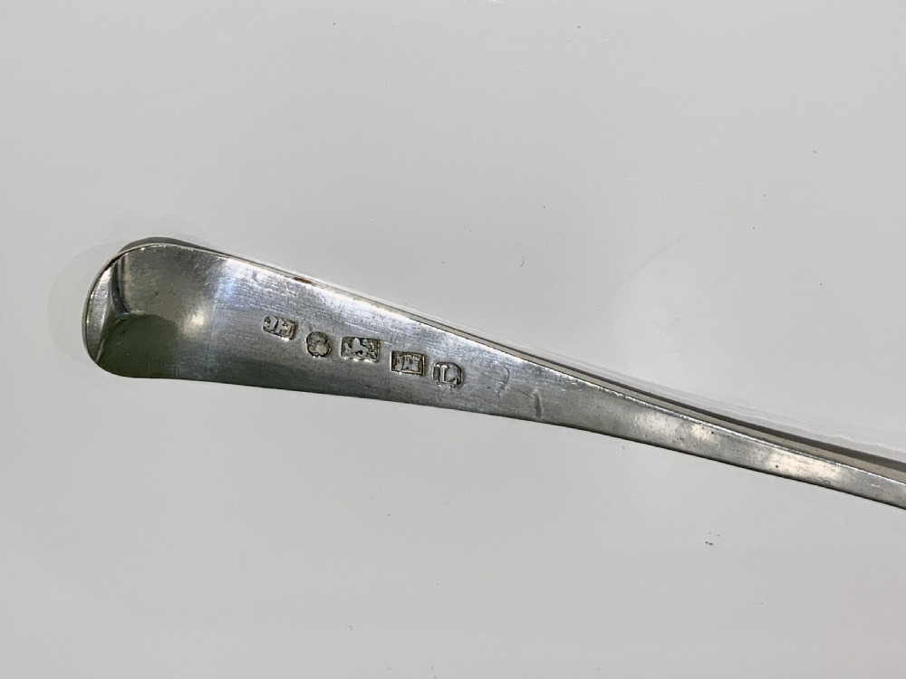 A Georgian sterling silver spoon featuring bright-cut hand engraving along the stem and an engraved monogram on the terminal. View IV