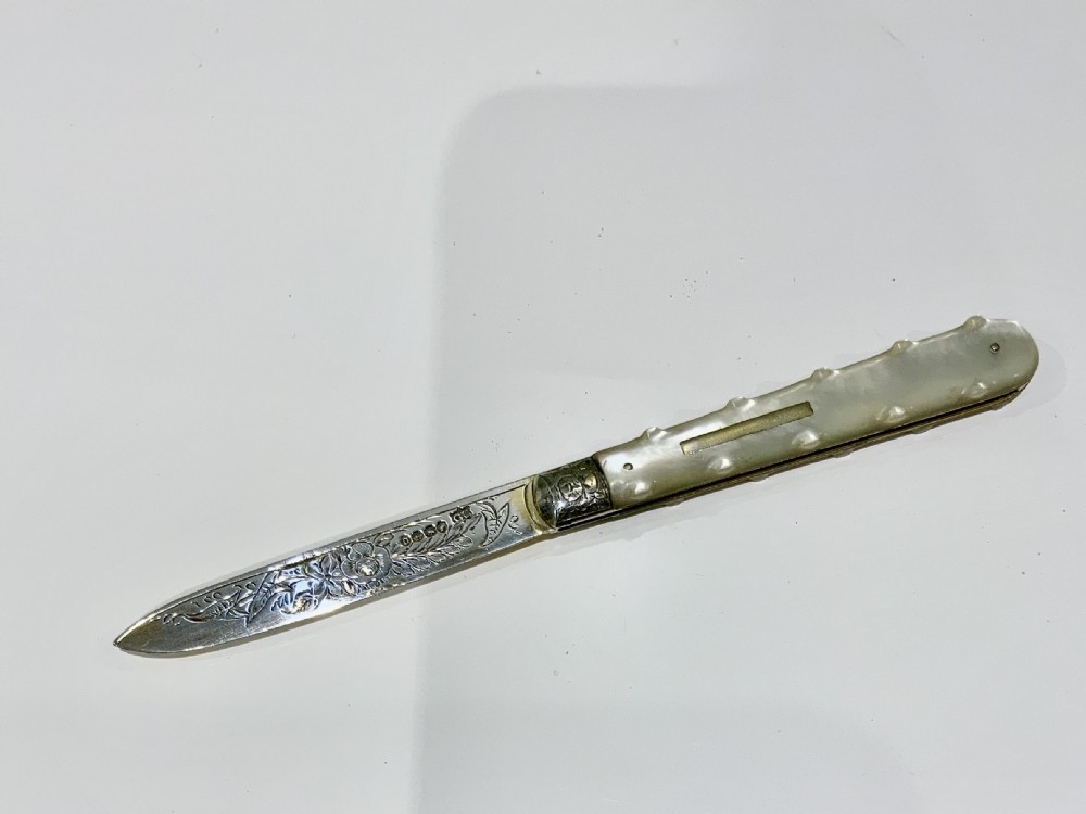 A Victorian folding fruit knife with an engraved sterling silver blade bearing official British hallmarks and a carved mother-of-pearl handle.