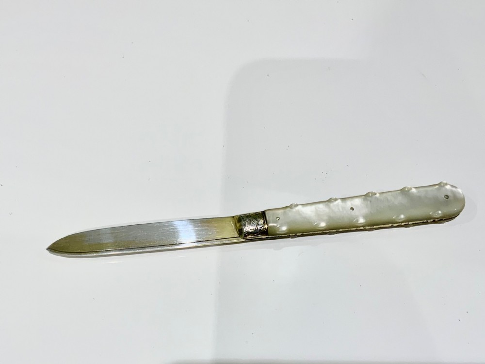 A Victorian folding fruit knife with an engraved sterling silver blade bearing official British hallmarks and a carved mother-of-pearl handle. View III