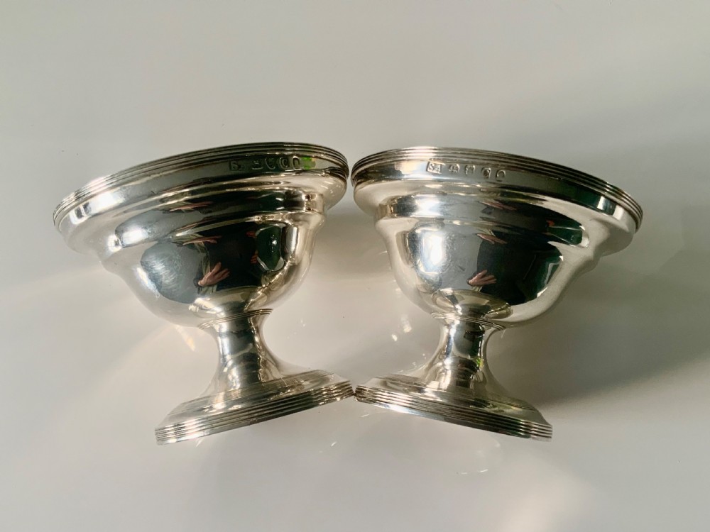 A pair of polished silver pedestal dishes featuring stepped circular bases and interior gold-gilded bowls. View II