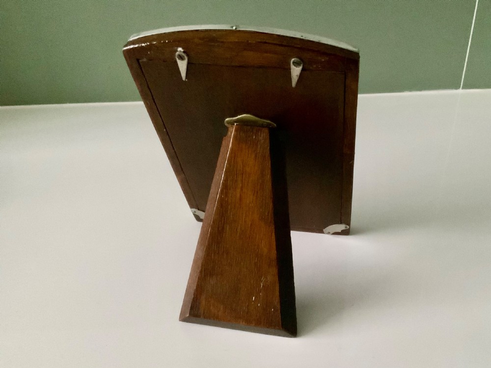 An upright Art Deco silver photograph frame with an arched top, engine-turned detailing, and a blue insert. View II