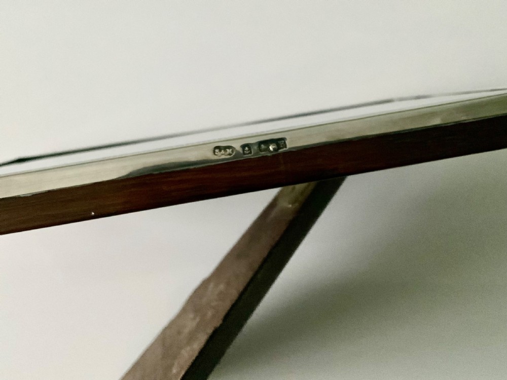 An upright Art Deco silver photograph frame with an arched top, engine-turned detailing, and a blue insert. View III