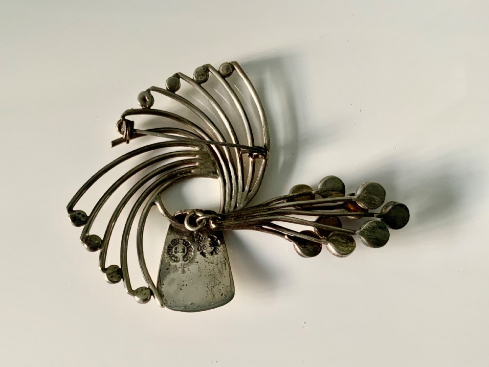 A Mexican sterling silver brooch designed with sweeping curved wires and hanging purple amethyst cabochons. View V