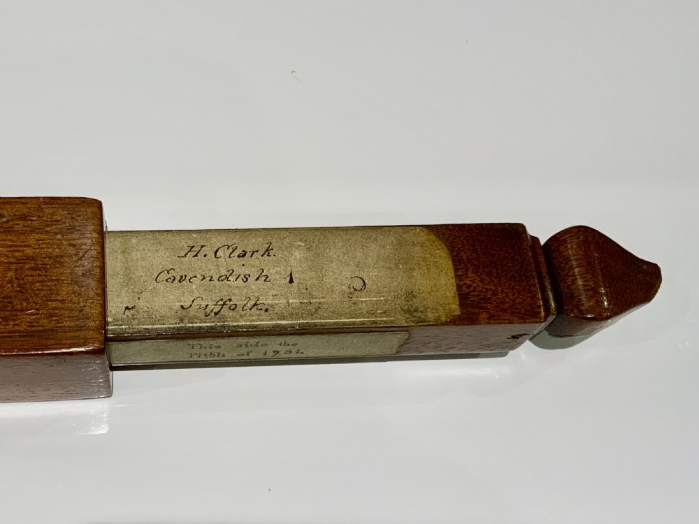 An elongated, rectangular wooden pitch pipe crafted from dark mahogany with a tapered mouthpiece at one end and a sound aperture. View IV