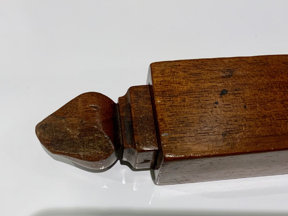 An elongated, rectangular wooden pitch pipe crafted from dark mahogany with a tapered mouthpiece at one end and a sound aperture. View VII