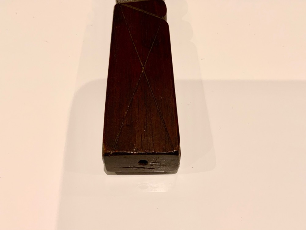 A dark carved wooden 19th-century knitting sheath featuring a heavy spiral-twisted shaft and an inset glass-covered handwritten inscription near the base. View IV
