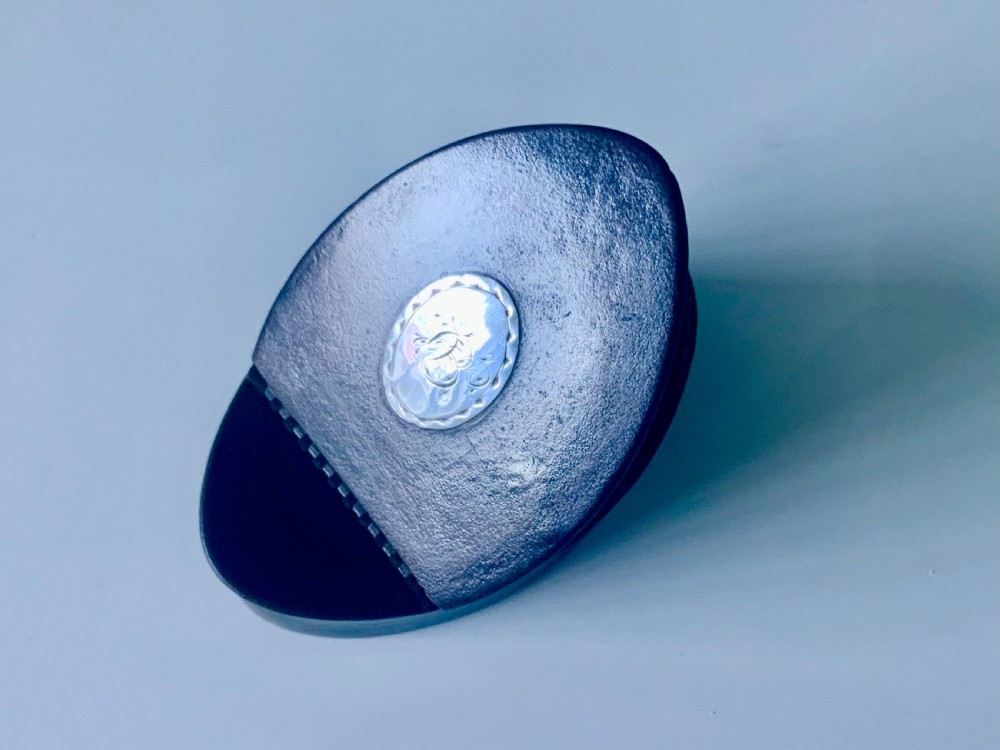 An oval dark brown leather Georgian snuff box featuring an engraved silver monogram cartouche on the lid. View II