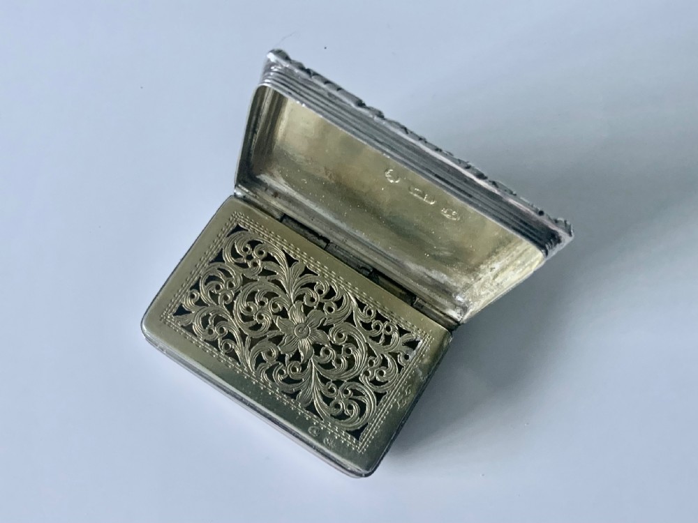 A small rectangular Georgian sterling silver vinaigrette featuring an engraved central cartouche with the inscription Remember Me, framed by basketweave engine turning and a floral cast border. View IV