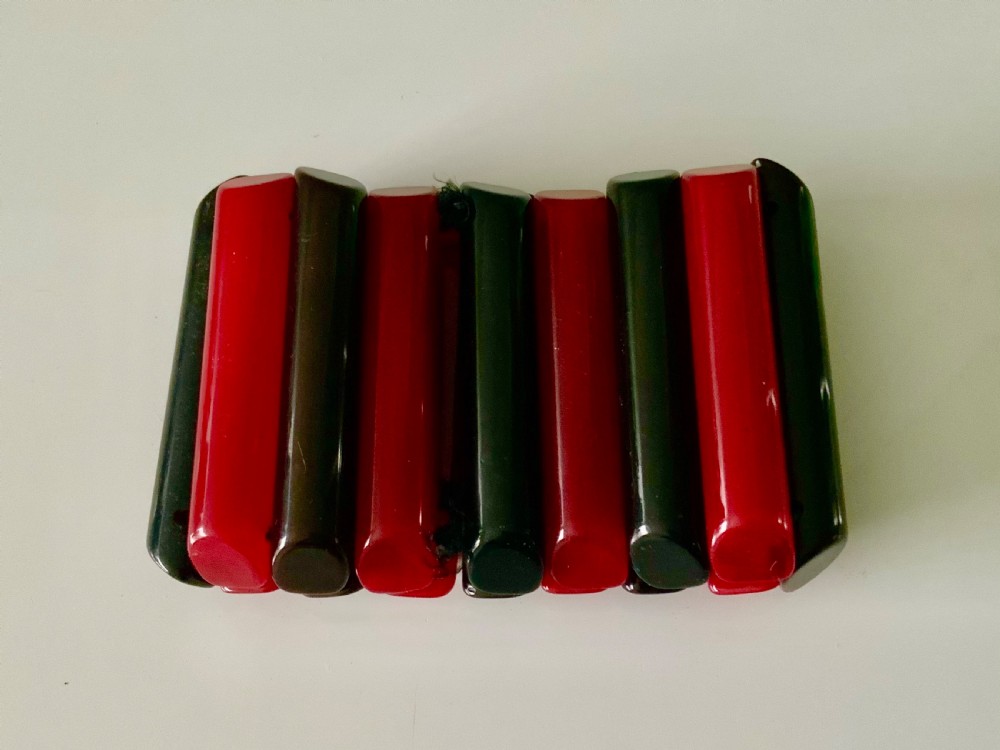 An early twentieth-century Art Deco stretch cuff bracelet featuring alternating vertical smooth red and black Bakelite segments. View IV