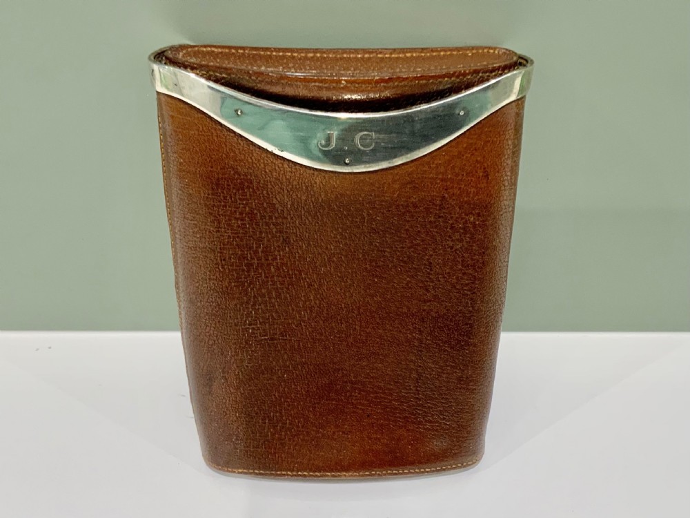 A stitched chestnut brown leather cigar case featuring a curved silver rim mount with engraved initials.