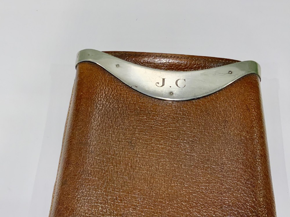 A stitched chestnut brown leather cigar case featuring a curved silver rim mount with engraved initials. View IV