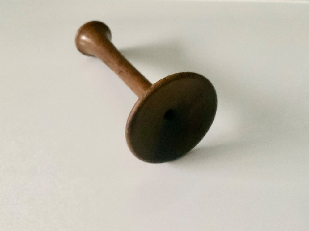 A 19th-century turned wooden monaural stethoscope with a slender stem and flared acoustic bell displayed upright. View II