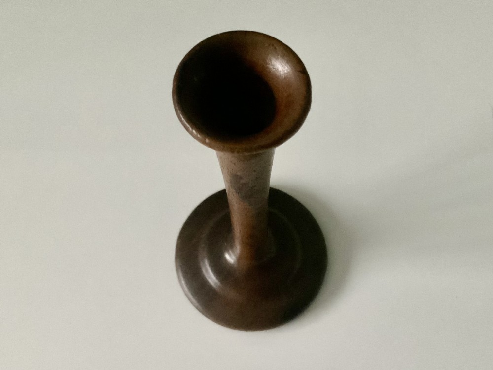 A 19th-century turned wooden monaural stethoscope with a slender stem and flared acoustic bell displayed upright. View III