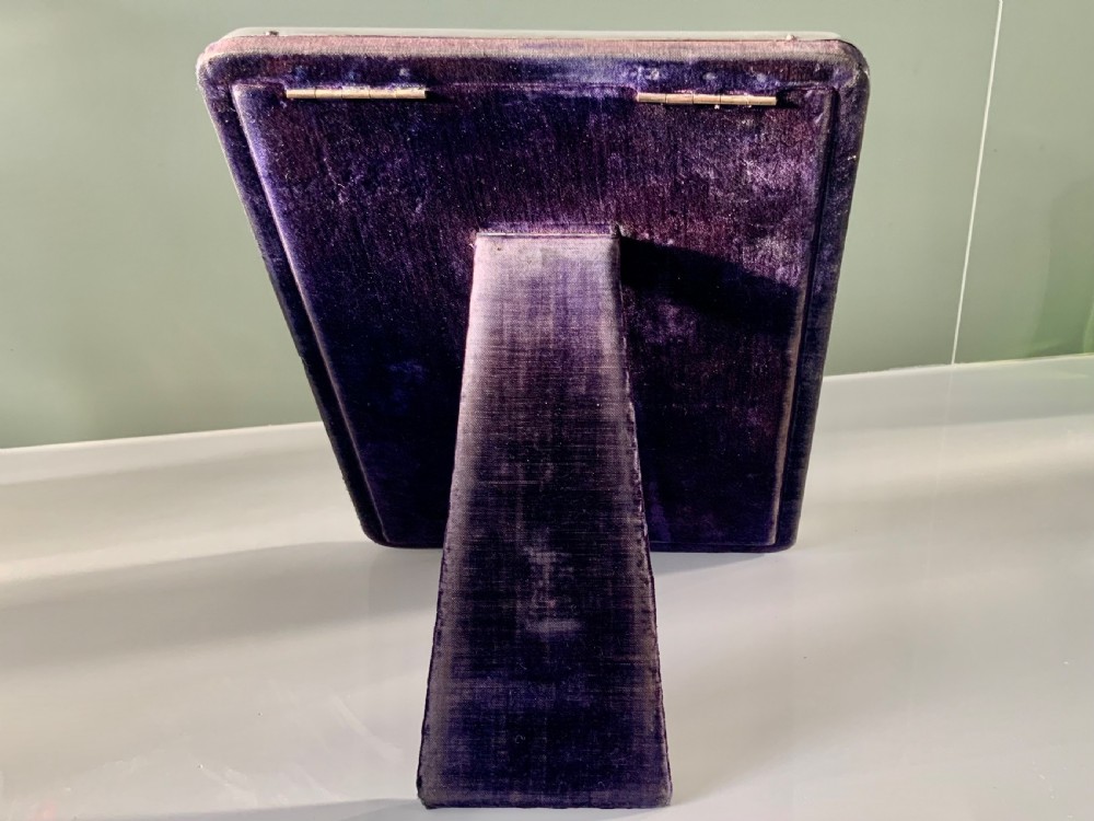 A rectangular sterling silver photograph frame with a plain polished border and dark blue velvet backing. View II