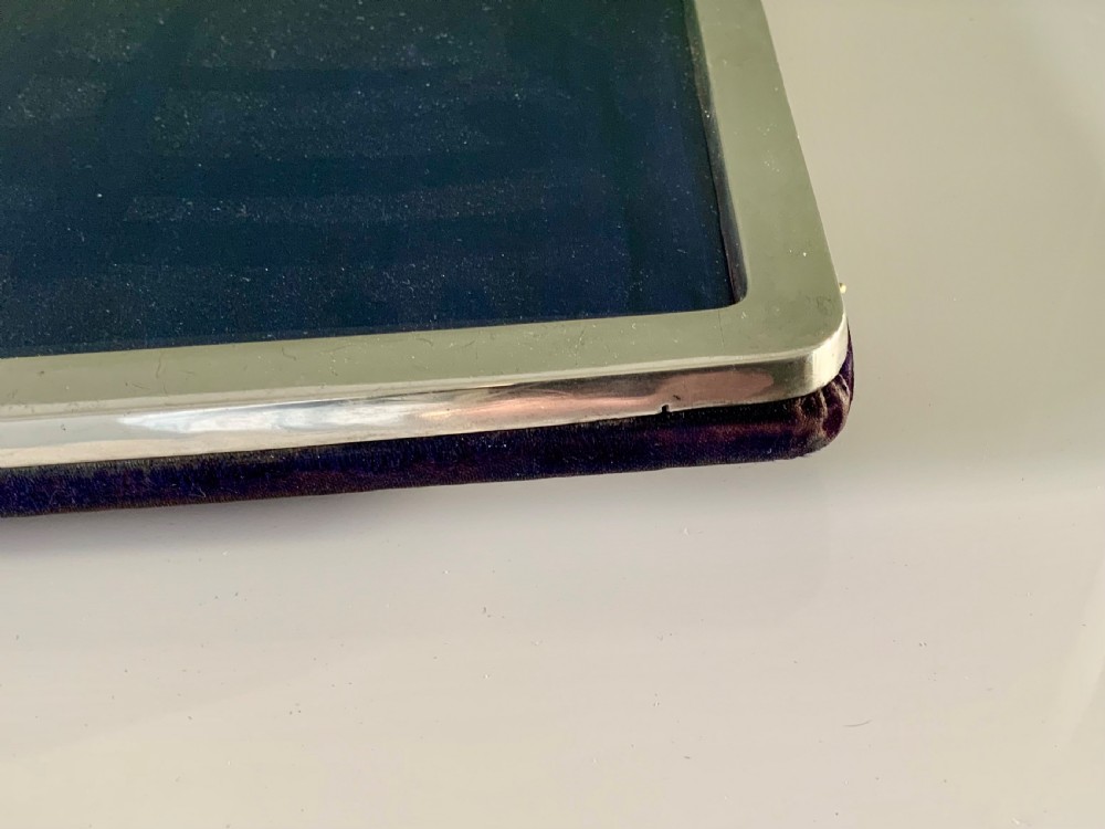 A rectangular sterling silver photograph frame with a plain polished border and dark blue velvet backing. View IV