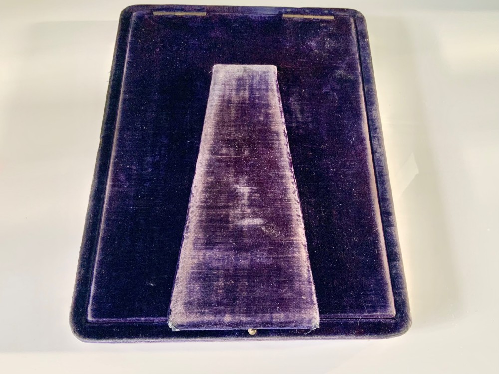 A rectangular sterling silver photograph frame with a plain polished border and dark blue velvet backing. View V