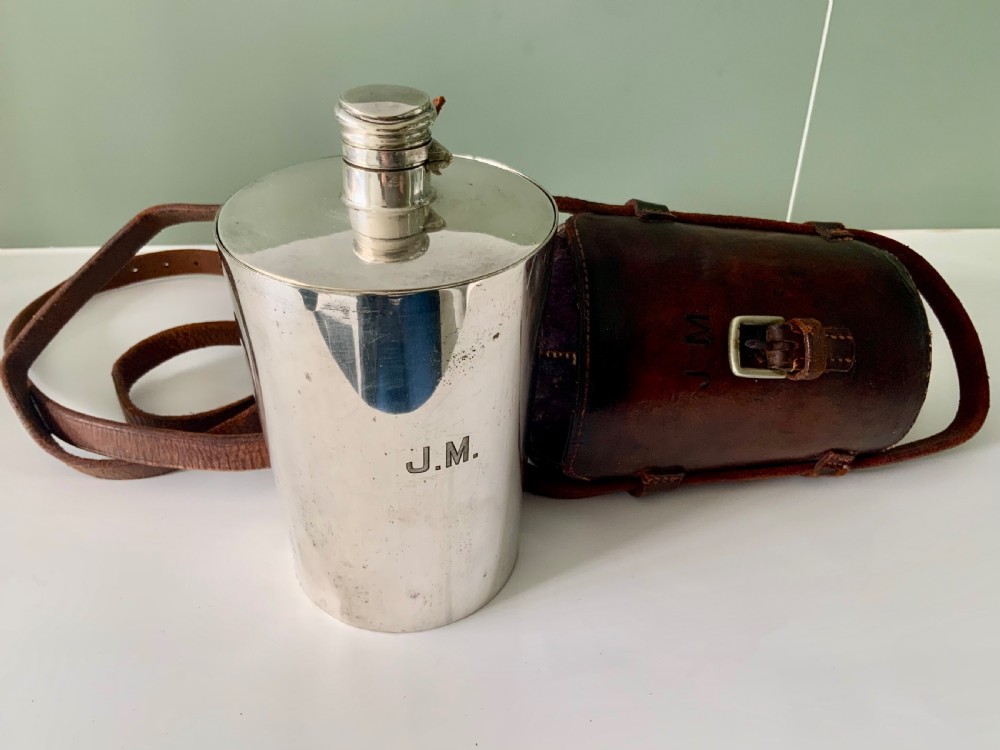 A Victorian silver-plated cylindrical flask engraved with initials alongside a dark brown leather carrying case with a shoulder strap. View III