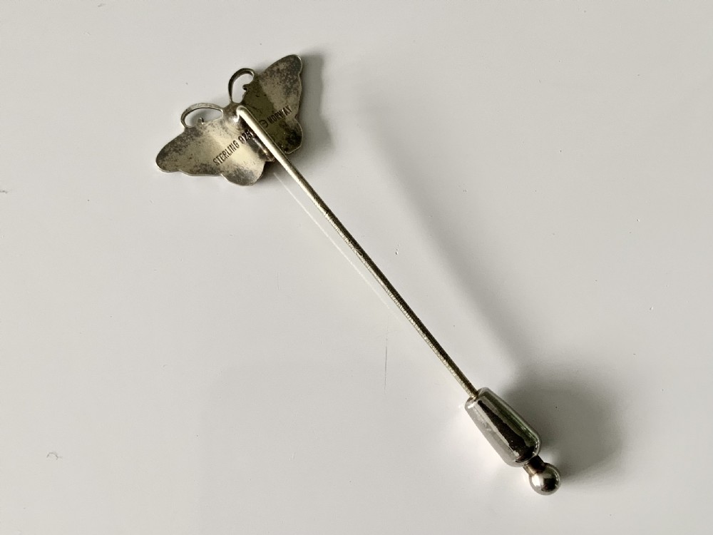 A vintage silver stick pin featuring a guilloche enamel butterfly in green, white, and brown tones. View III