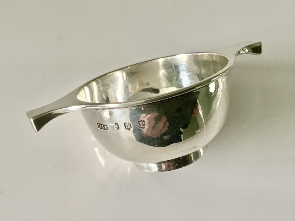 A small polished silver Scottish quaich featuring a shallow central bowl and two flat, symmetric side handles. View II